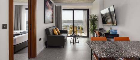 A modern living room with a sofa, a dining table, and a TV.
