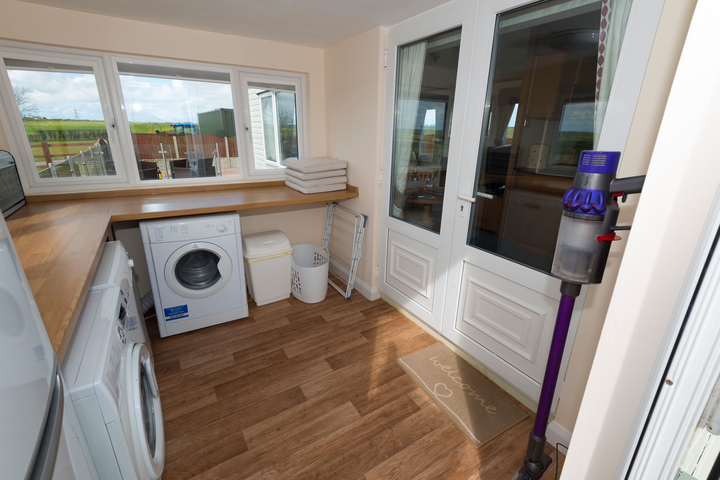 A laundry room with a washing machine, dryer, and stacked white laundry baskets.