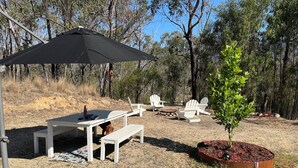 Un espace extérieur aménagé avec une table, des chaises et un petit arbre.