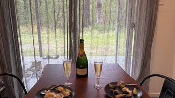 Un tavolo con due piatti di cibo, una bottiglia di champagne e due bicchieri da champagne.