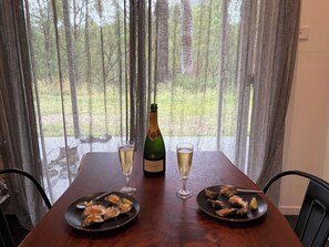 Een tafel met twee borden eten, een champagnefles en twee champagneglazen.