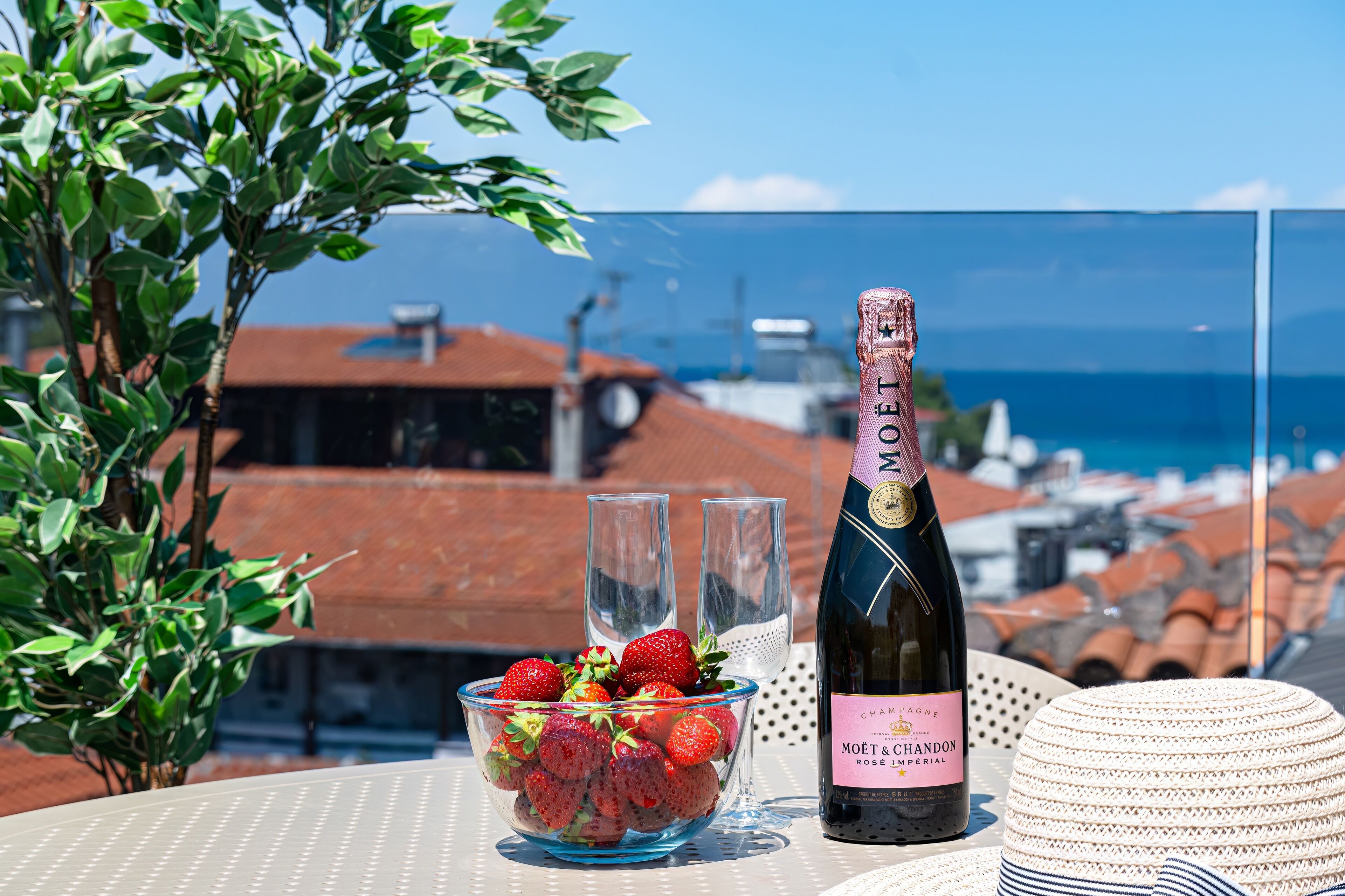 Una mesa con una botella de Moët & Chandon, un bol de fresas y dos copas.