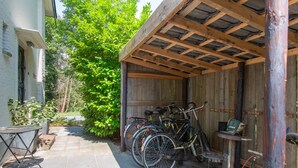 A covered outdoor area with bicycles parked under a wooden structure. - B&B Koepel Enschede (Enschede)