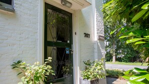 A white brick building with a green door and the number 707. There are potted plants in front of the door. - B&B Koepel Enschede (Enschede)