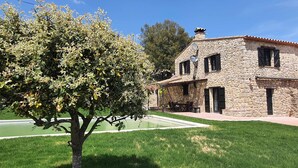 Una casa de piedra con un patio y un jardín.