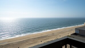 Uitzicht op het strand vanaf een balkon, met een heldere lucht.