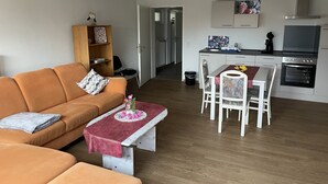 A modern apartment with a living room, dining area, and kitchen. - Vacation apartment in the countryside (Lebach Landsweiler)