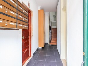 Staircase leads to a hallway with a door and metal filing cabinet.