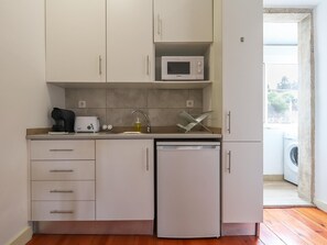 A compact kitchen with a microwave, toaster, coffee maker, and dishwasher.