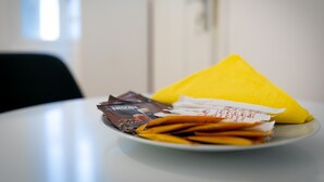 En tallrik med ett gult, triangulärt föremål, flera chokladkakor och ett vitt, rektangulärt föremål på ett bord.