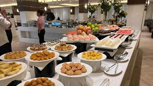 Un bufé con diversos platos, incluyendo pasteles, frutas y postres.
