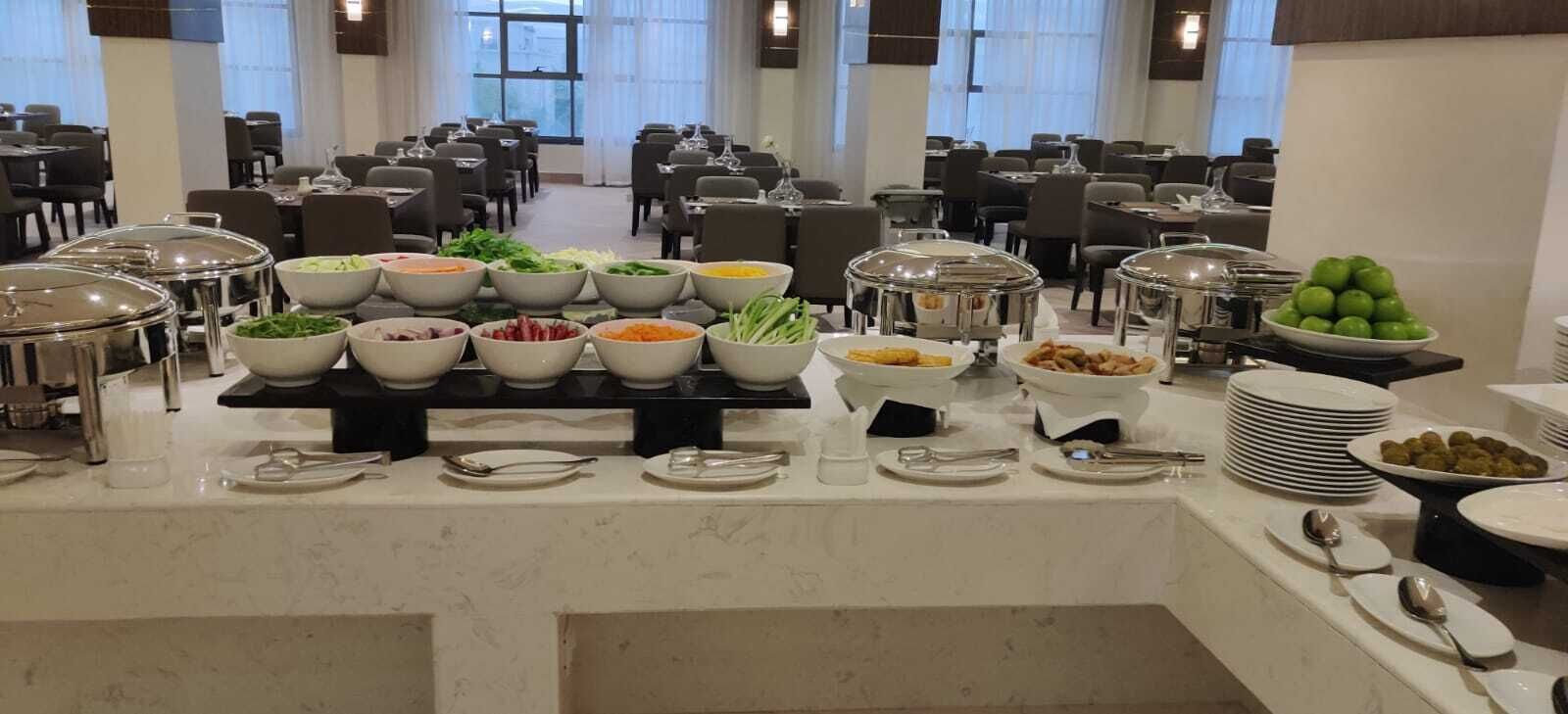 A buffet setup with various food items and utensils.