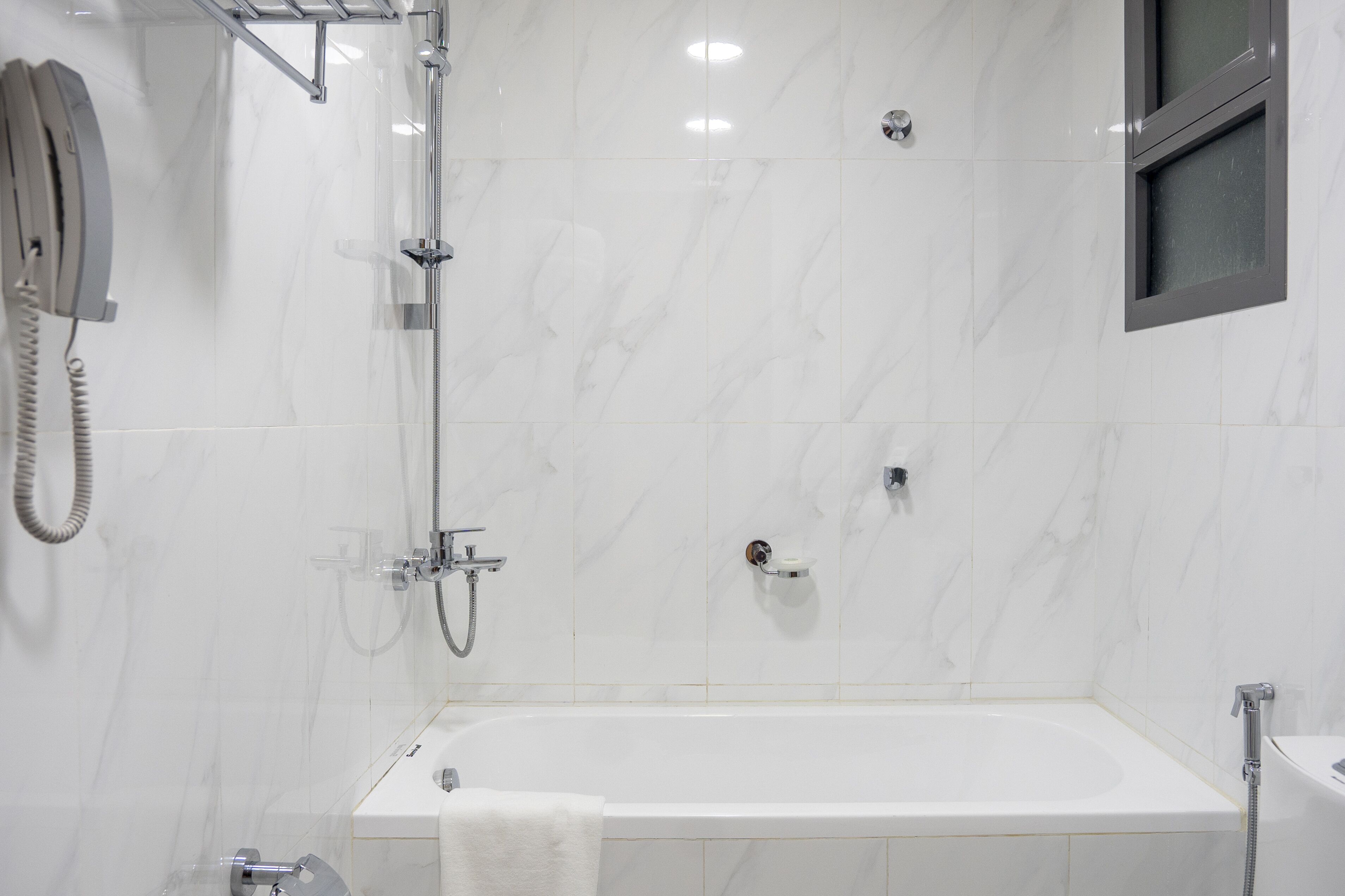 A modern bathroom with a bathtub, a shower, and a toilet.