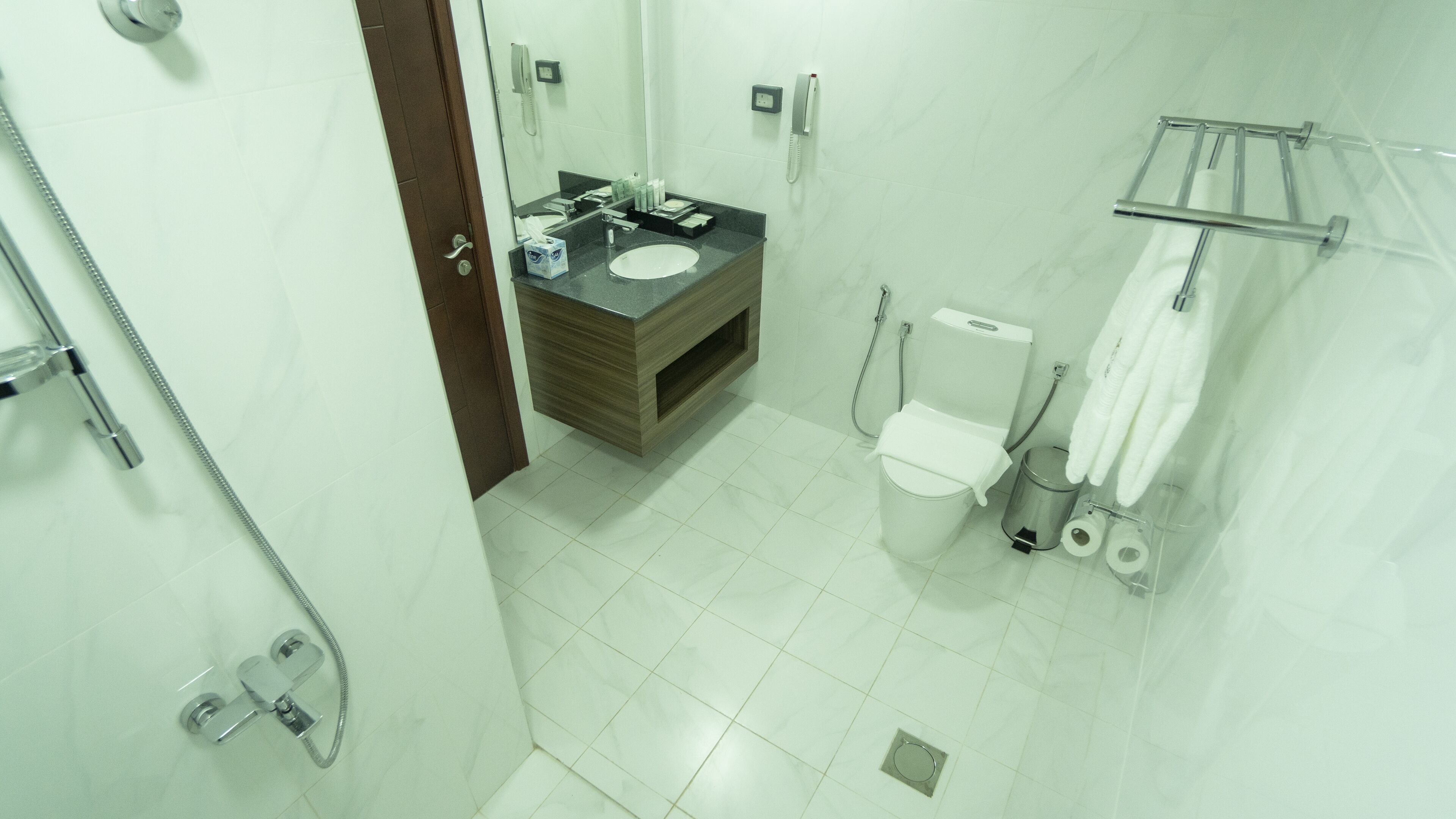 A modern bathroom with a toilet, bidet, and a sink with a mirror.