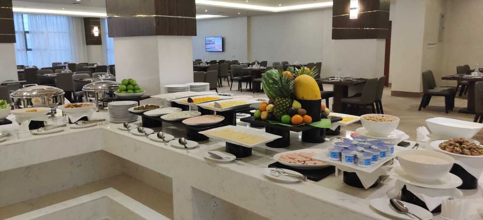 Ein Buffet mit verschiedenen Speisen und einer Obstauslage in einem Hotelrestaurant.