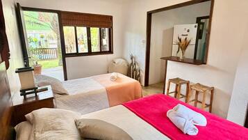 Habitación de hotel con dos camas, un ventanal grande, un espejo y una lámpara en el techo.
