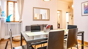Zona pranzo con tavolo, sedie e un lampadario.