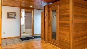 Un intérieur en bois avec une porte, un sol carrelé et un tableau encadré au mur.