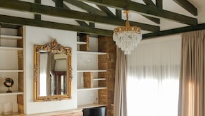 A living room with a fireplace, a television, and a chandelier. - Marble Luxury Suites (Heraklion)