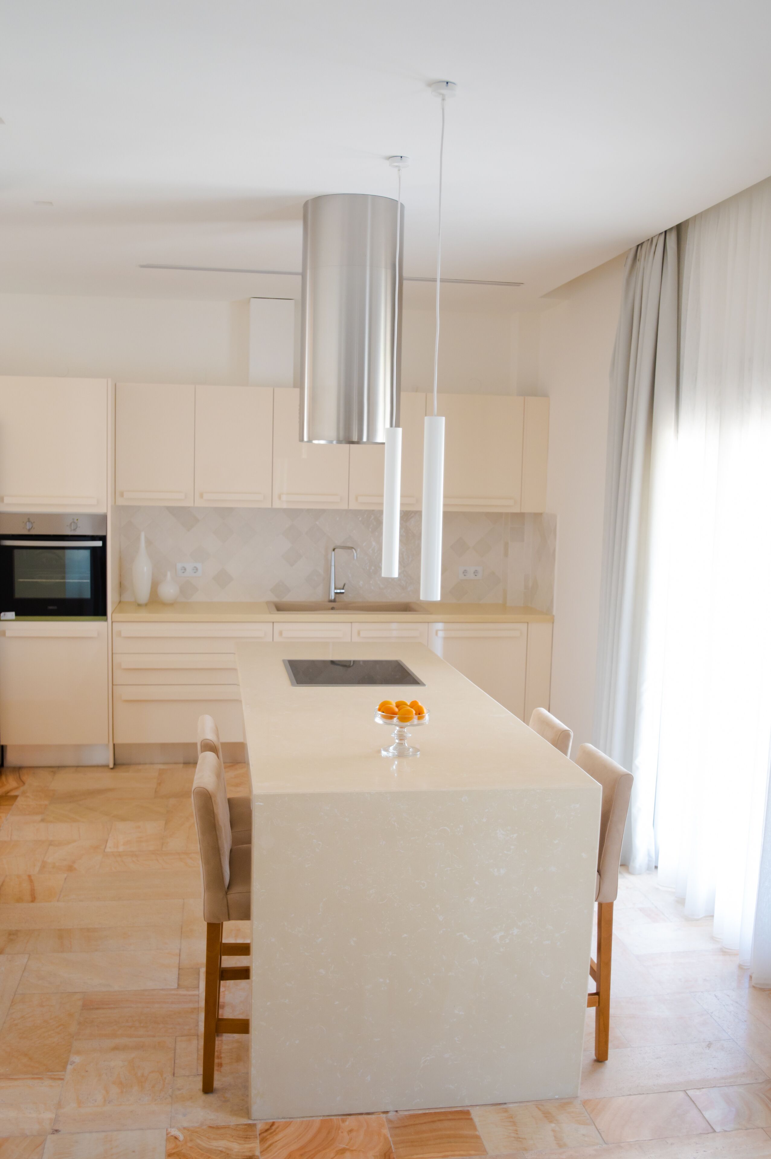 A modern kitchen with a central island, stainless steel appliances, and pendant lighting.