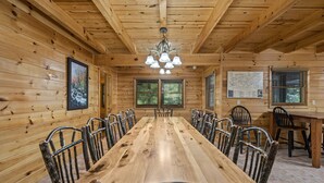 A wooden cabin with a long dining table and chairs, a chandelier, and a map on the wall. - RIVERFRONT! EASY DRIVE TO GATLINBURG AND PIGEON FORGE! GAMEROOM! MOVIE THEATER! (Sevierville)