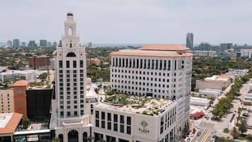 Un edificio de gran altura con una torre destacada y un jardín en la azotea.