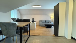 Un salon moderne comprenant un coin repas, un canapé, une table basse et une lampe.