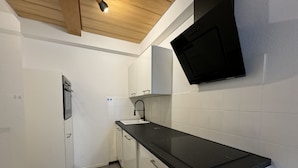 A kitchen with white cabinets, a black countertop, and a built-in microwave.