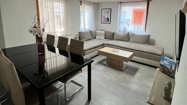 Una sala de estar moderna con una mesa de comedor, sofá y mesa de centro.