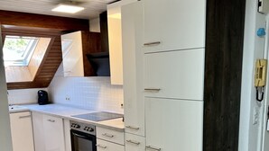 A modern kitchen with white cabinets, a built-in oven, and a skylight. - Ferienhaus Möhrle 7 (Ueberlingen)