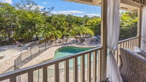 A pool with a view of palm trees and lounge chairs.