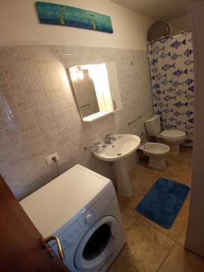 Combinació de dutxa i banyera, assecador de cabells, bidet i tovalloles