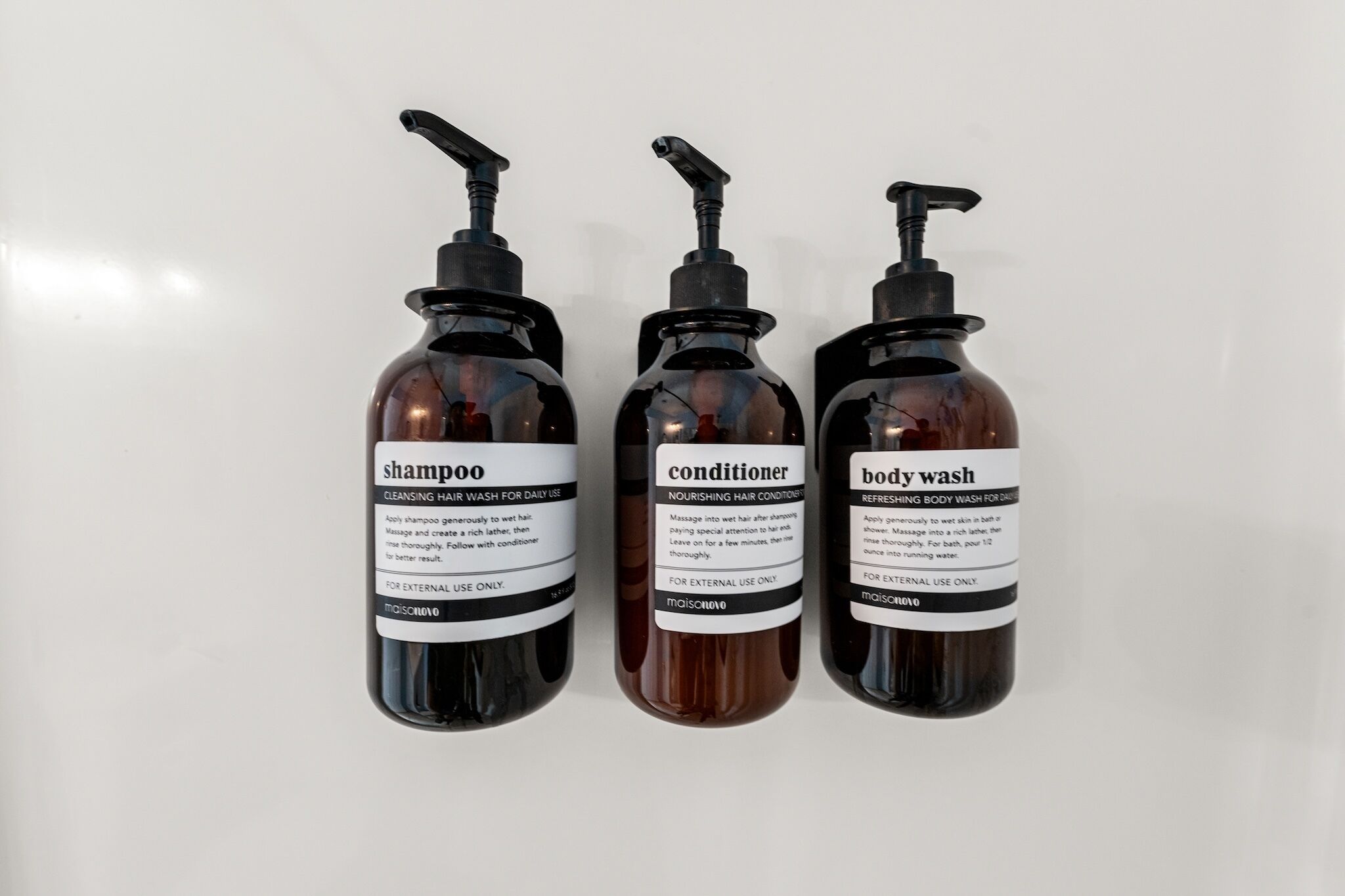 Three bottles of hair care products: shampoo, conditioner, and body wash.