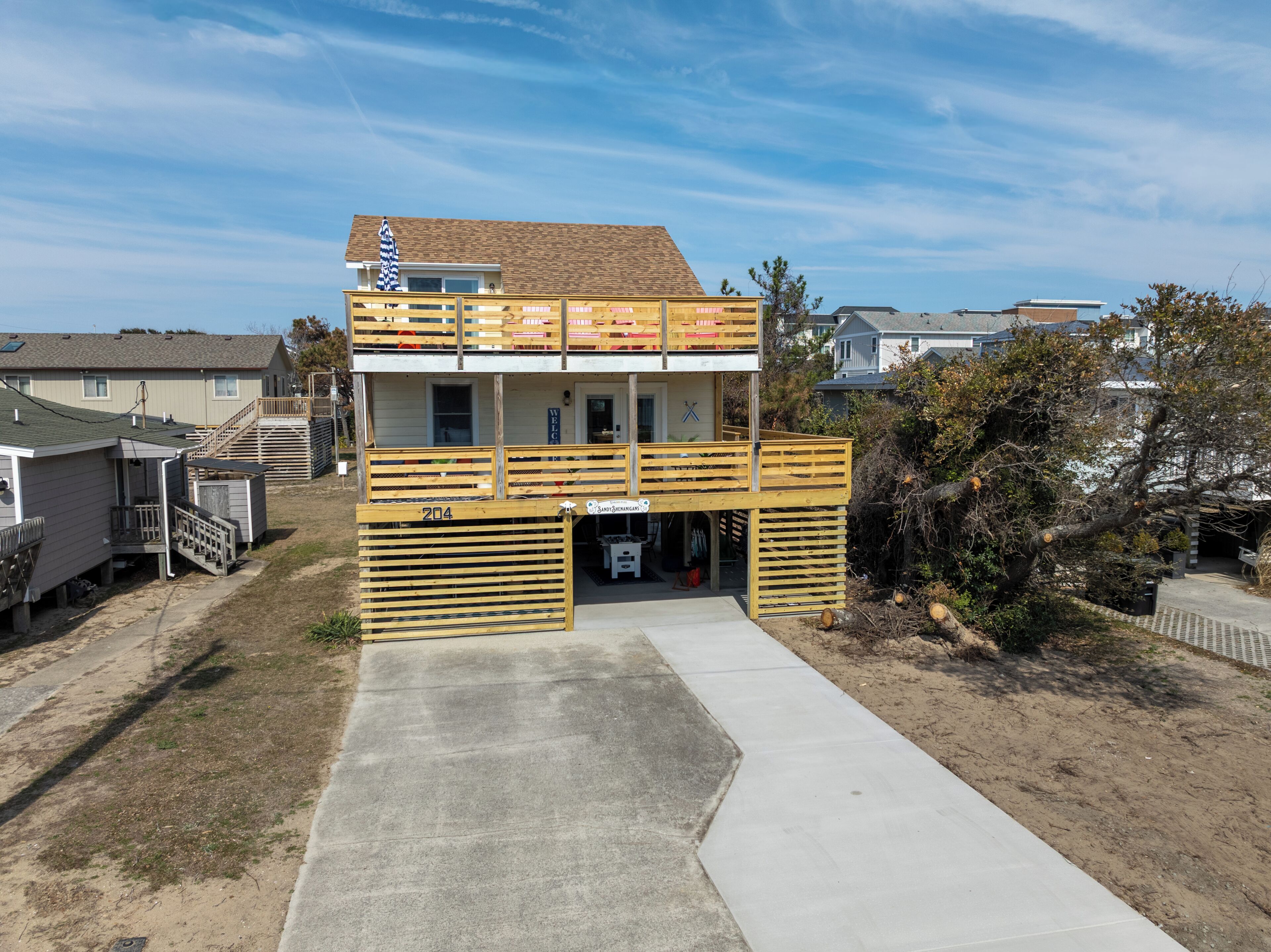 A two-story building with a balcony, a garage, and a small porch.