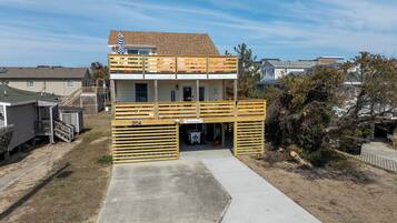 A two-story building with a balcony, a garage, and a small porch.