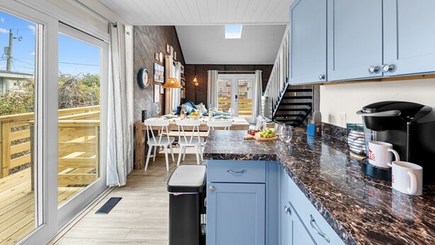 A modern kitchen with a large island, a coffee maker, and a view to the outside. - Beach Cottage · Hot Tub · Rooftop · Movie Room (Kill Devil Hills)