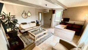 Una sala de estar moderna con sofá, mesa de centro y comedor con mesa y sillas.