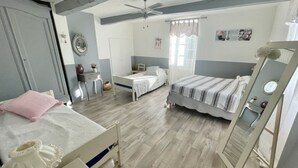 Un dormitorio con cama, escritorio, silla, armario y espejo.