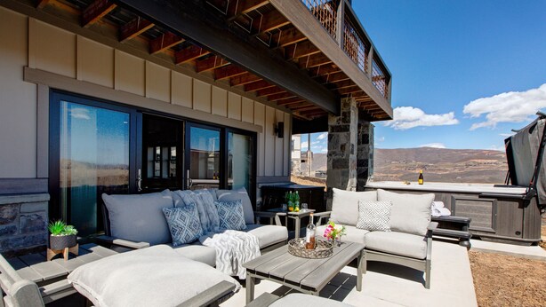 An outdoor patio with a sofa, coffee table, and hot tub. - Near Jordanelle & Deer Valley with Mountain & Lake Views, Hot Tub, Game Room & More! (Heber City)
