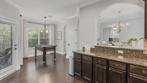 A modern kitchen with dark wood cabinets, granite countertops, and a large island. - Walk to the Beach ~ Biking Trails (Santa Rosa Beach)