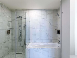 Une salle de bain moderne avec une douche à parois de verre, une baignoire sur pieds et des carreaux de marbre.
