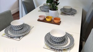 A dining table set with patterned plates, bowls, and a potted plant. - Modern 3 bedrooms house with 6 guests (Sheffield)