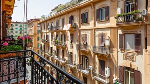 A row of traditional European buildings with balconies, some with plants and flowers. - Via Pasquale 16 in Napoli (Naples)