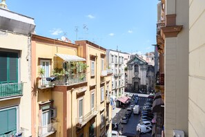 Una calle estrecha con coches aparcados y edificios a ambos lados.