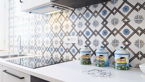A kitchen with a modern design, featuring a patterned backsplash, a stainless steel sink, and a countertop with jars. - Corso Umberto 58 in Napoli (Naples)