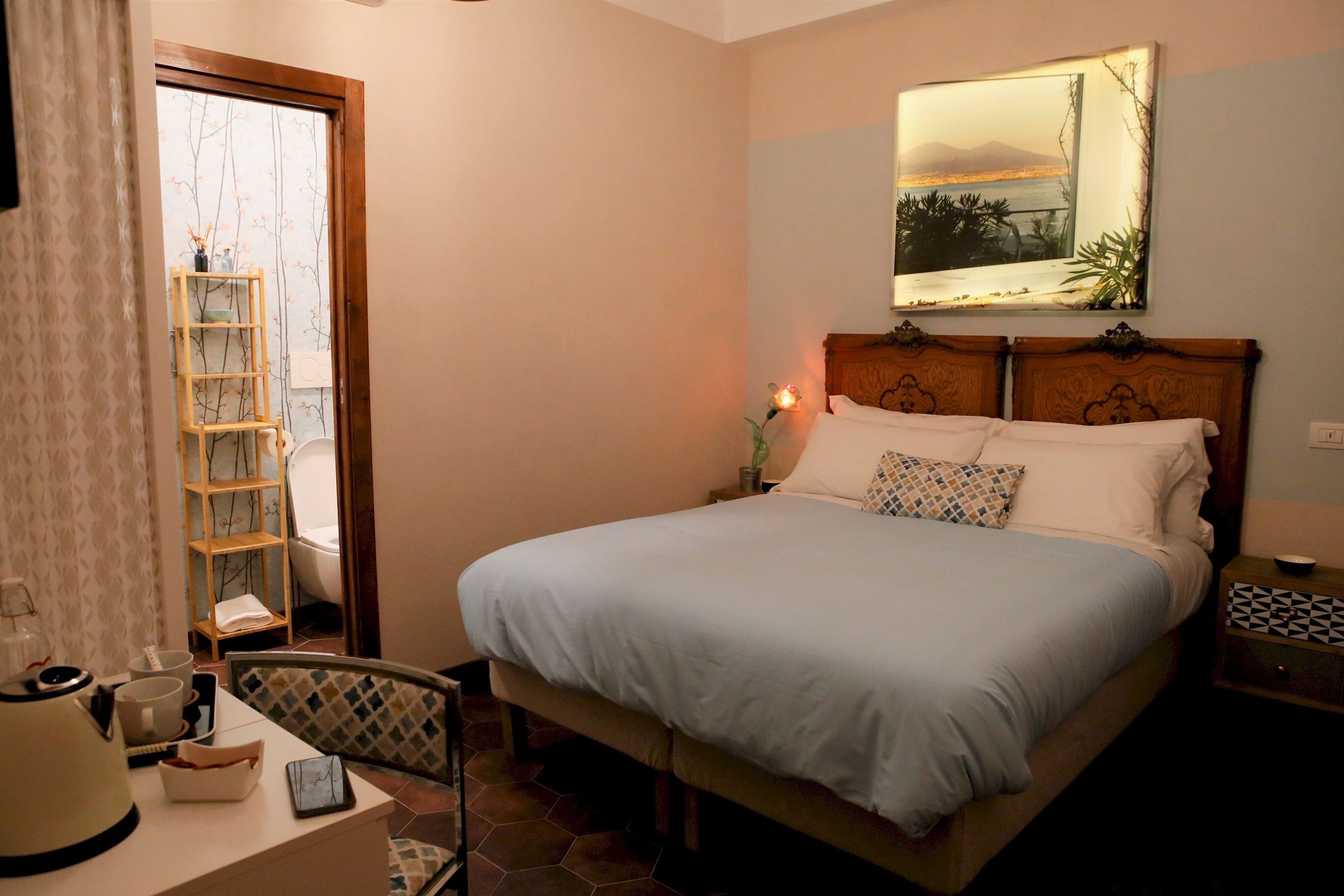 A bedroom with a bed, bedside table, and a nightstand.