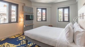 A hotel room with a bed, a TV, and a window with a view of buildings. - Ibis Budget Tbilisi Center (Tbilisi)