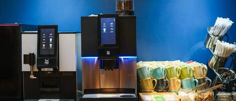 Un espace dédié au café, équipé de plusieurs machines à café et proposant une variété de tasses et de récipients.