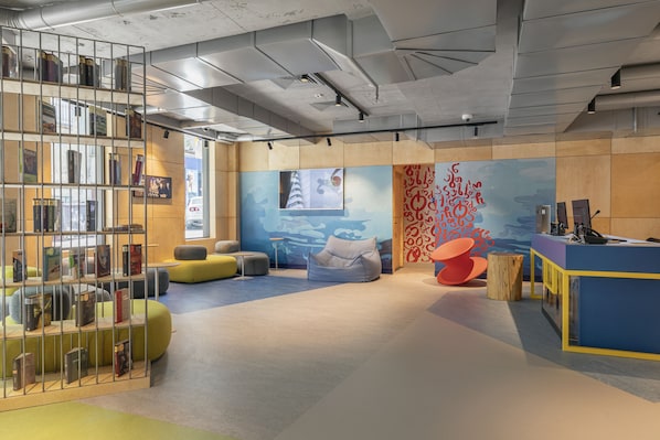 Una biblioteca moderna con scaffali, zone relax e una reception.