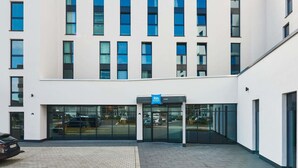 A modern building with a sign 'ibis budget' and a glass entrance. - Ibis Budget Singen (Singen)